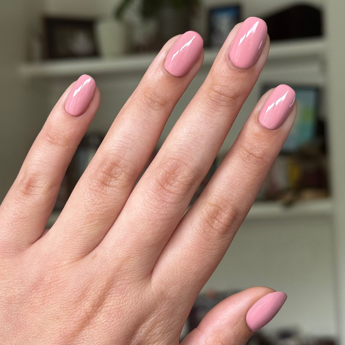 Lovely gel polish in soft dusty rose shade on rounded nails with a smooth, glossy finish in natural light