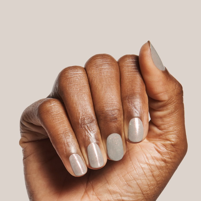 Hand with Moonlit gel polish in sheer grey and holographic flakes showing a quick dry mani on natural skin tone