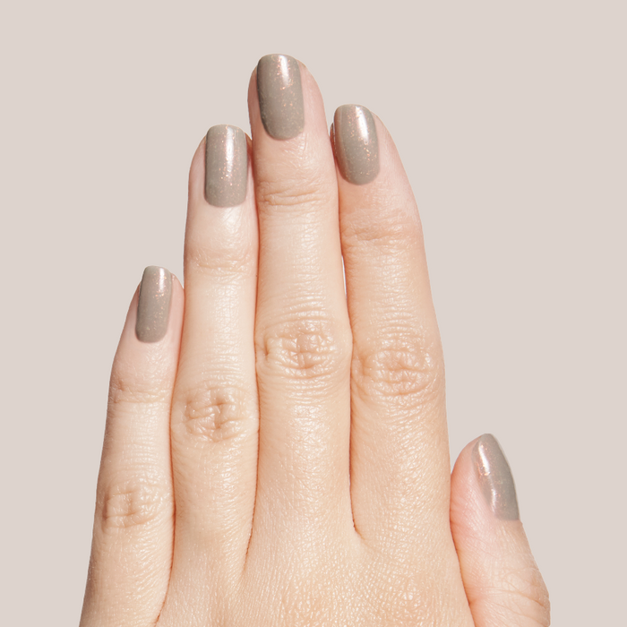Hand displaying nails painted with Moonlit sheer grey quick dry gel polish with subtle holographic shimmer