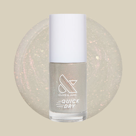 Bottle of Moonlit quick dry gel polish with milky sheer grey base and subtle holographic flakes on beige background