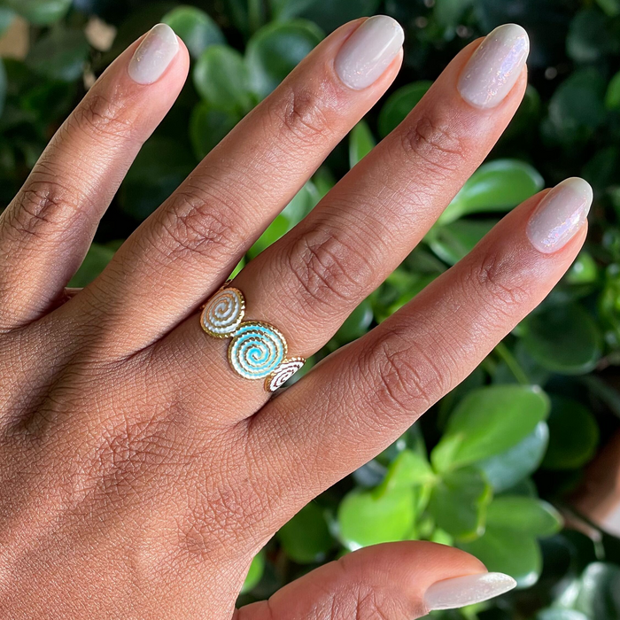 Hand with Moonlit gel polish manicure in sheer milky grey and holographic flakes against green plant background