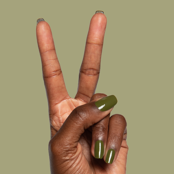 Hand showing peace sign with glossy Mossy quick dry gel polish manicure on natural nails against plain background