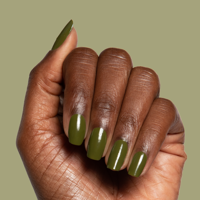 Hand with nails painted in glossy Mossy gel polish showing smooth quick dry manicure on natural nails