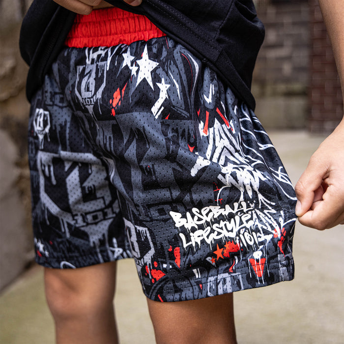 Youth model wearing gray youth shorts with “Night Game Drip” design