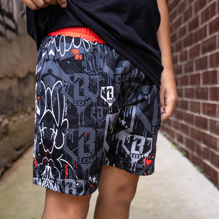 Youth model wearing gray youth shorts with “Night Game Drip” design