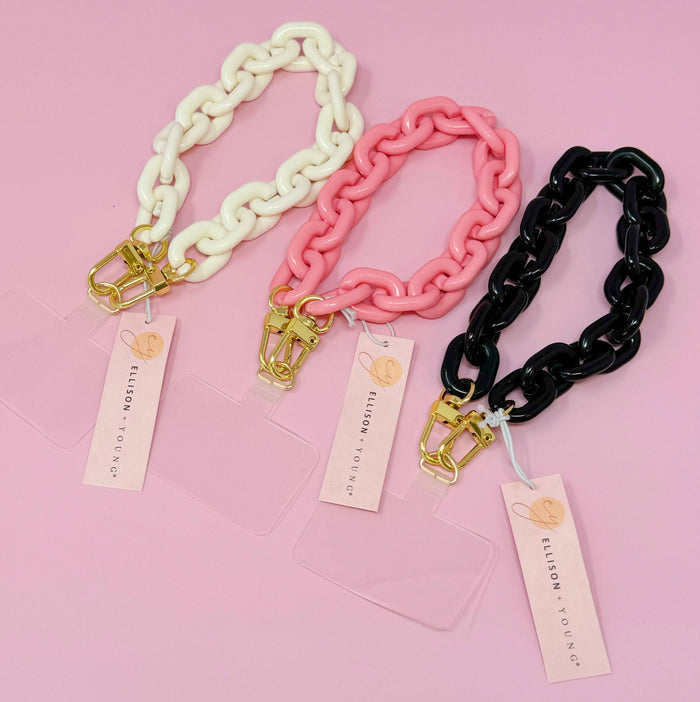 Ellison+Young phone wrist lanyard with strap, designed for secure holding of smartphones, in a close-up view.