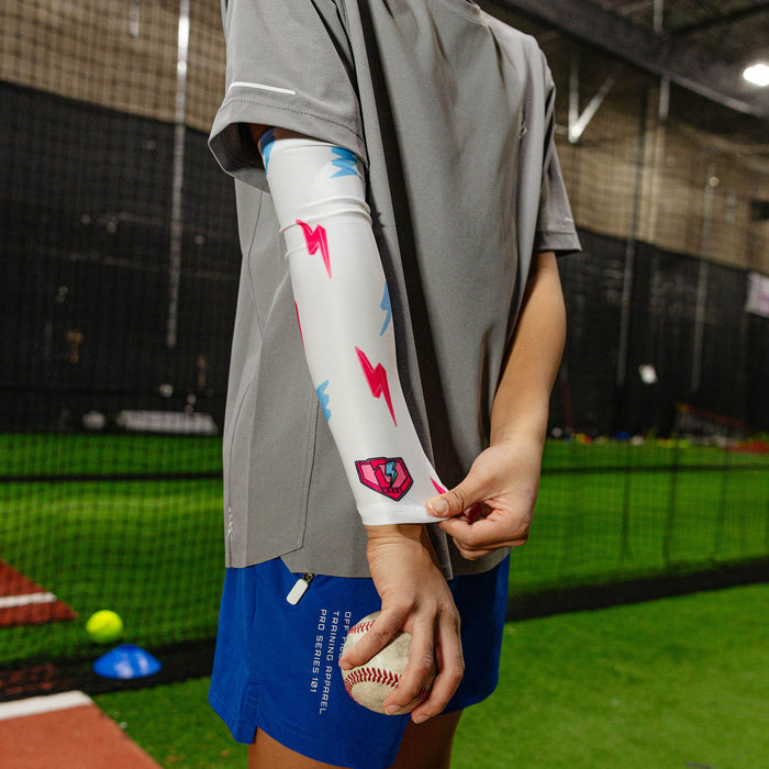 Youth model wearing white and pink and blue Rain Delay Lightning Arm Sleeve youth sleeve