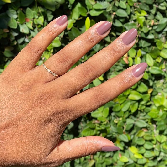 Hand with medium skin tone wearing smooth Sable gel polish manicure with natural nails outdoors in sunlight