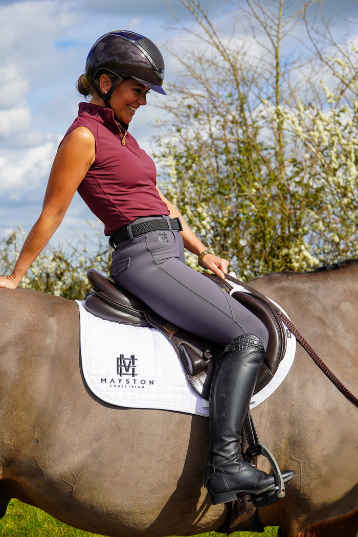 Burgundy sandford sleeveless base layer. Ultra-soft technical sport fabric. Breathable and lightweight for warmer weather. Flattering athletic fit
Signature black branded Mayston collar. Subtle gloss shoulder logo detail. Sleeveless design for unrestricted movement.