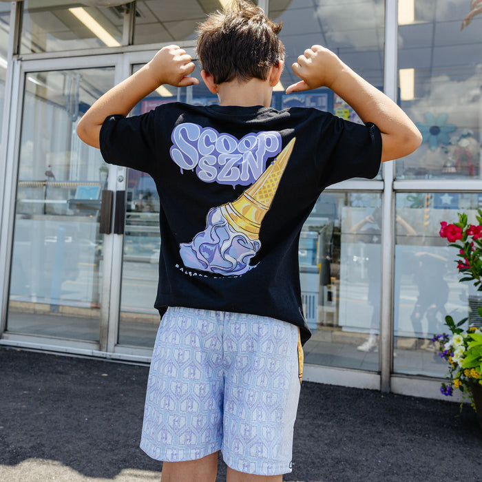 Youth model wearing youth shorts with "Scoop SZN" design