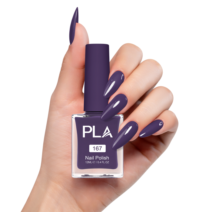 Hand holding a purple nail polish bottle with matching nails on a white background