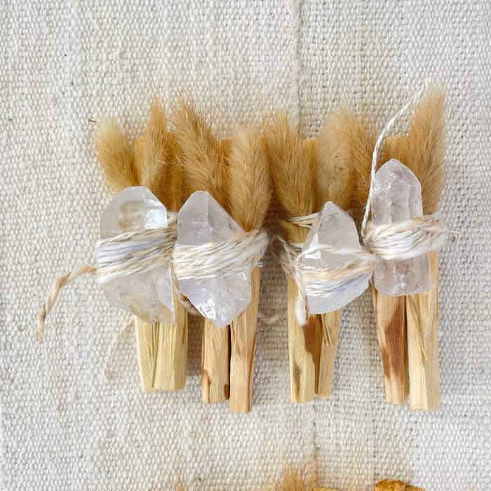 Palo santo bundle with several clear crystal points on tied short sticks