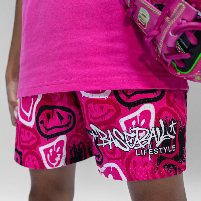 Close up of person wearing pink shirt and pink shorts with black and white smiley graphics on a white background