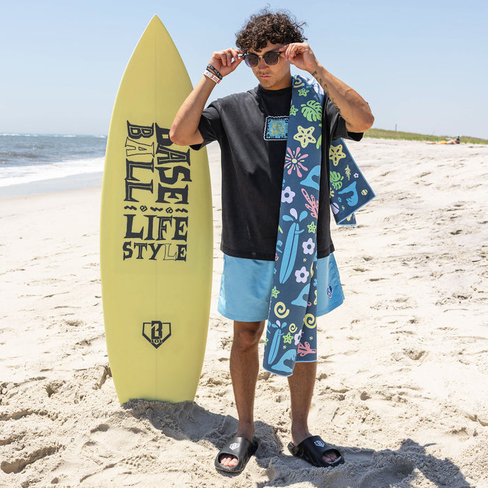 Adult model wearing multi-color towel with "Surfside Slugger" design