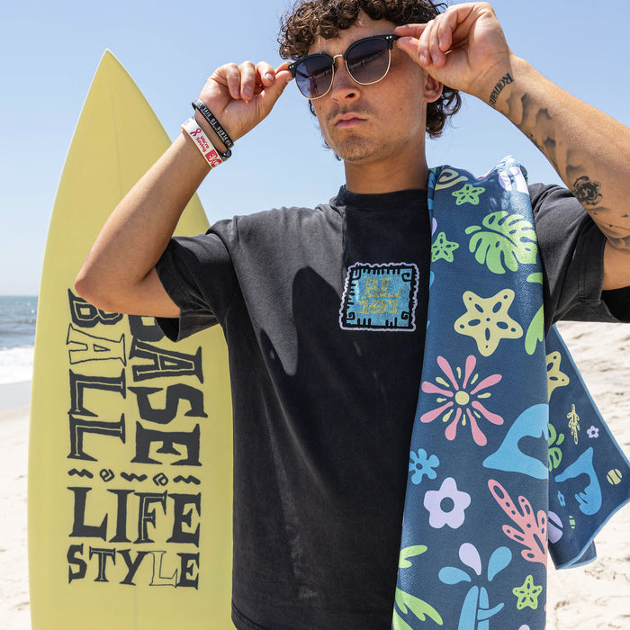 Adult model wearing multi-color towel with "Surfside Slugger" design