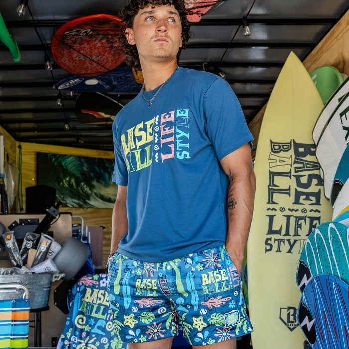 Adult model wearing multi-color shorts with "Surfside Slugger" design