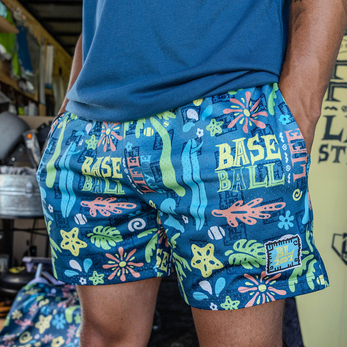 Adult model wearing multi-color shorts with "Surfside Slugger" design