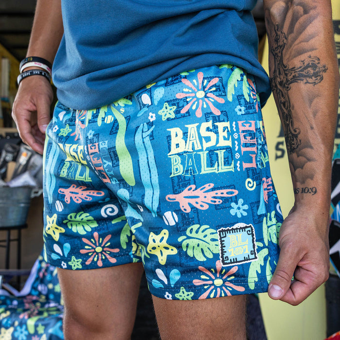 Adult model wearing multi-color shorts with "Surfside Slugger" design