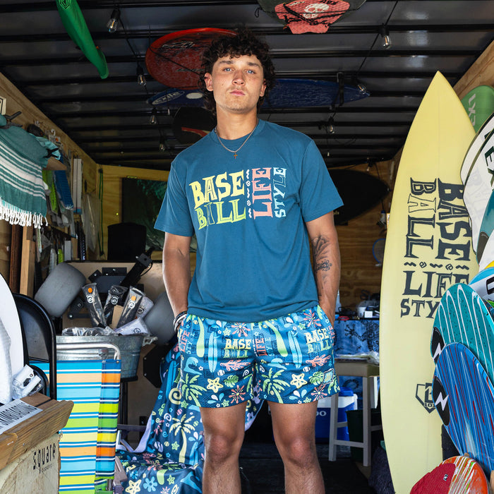 Adult model wearing blue graphic tee with "Surfside Slugger" design
