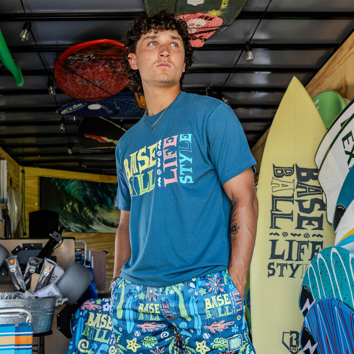 Adult model wearing blue graphic tee with "Surfside Slugger" design