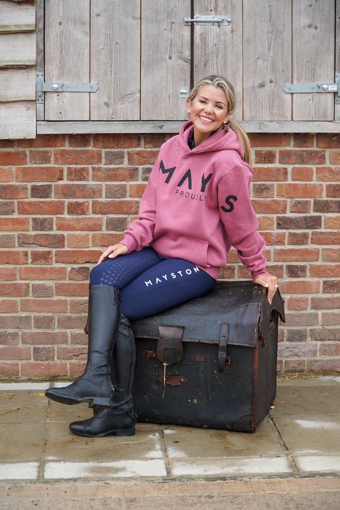 Woman in pink hoodie and blue breeches sitting on a suitcase with 'Mayston' branding against a brick wall.
High quality luxurious 100% cotton. wrap around bold logo. soft, cozy and  warm. Hoodie, jumper sweatshirt. everyday wear. casual and smart