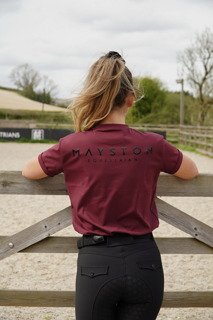 Crafted from a luxuriously soft technical sports fabric in a breathable nylon blend with stretch, it offers a smooth, lightweight feel that moves effortlessly with you — from stable life to everyday wear. Burgundy Short Sleeve tee, high gloss mayston branding