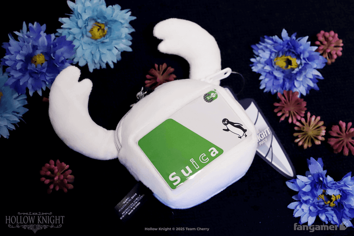 The back of the Knight pouch, photographed against a floral background, showing the clear slot for credit-card-sized transit passes or anything else with tap-to-pay functionality. This image shows a Suica card.