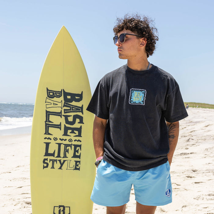 Adult model wearing black graphic tee with "Wave Goodbye" design