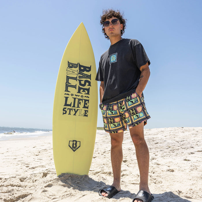 Adult model wearing multi-color shorts with "Wave Goodbye" design