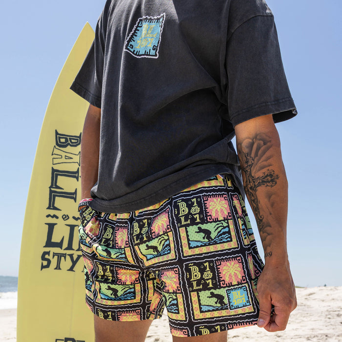 Adult model wearing multi-color shorts with "Wave Goodbye" design