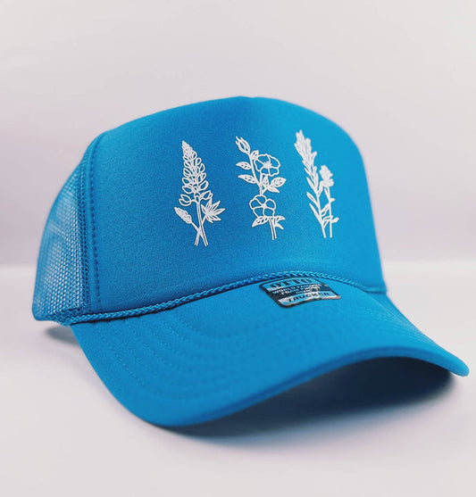 Wildflowers adult trucker hat in turquoise by Made of Mountains, featuring a floral pattern and adjustable mesh back.